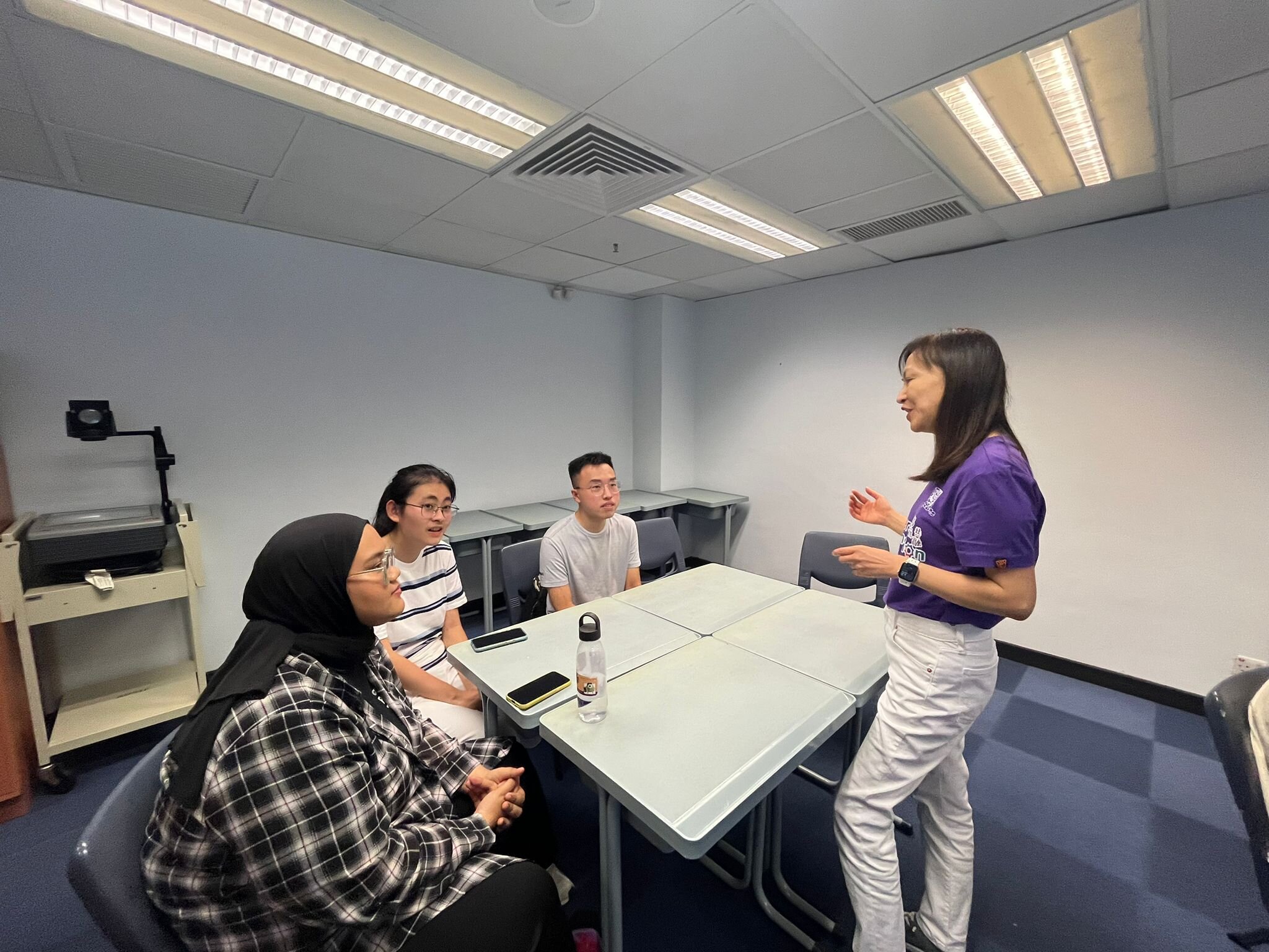 Ms. Lily Chung, the director of the Diversity and Inclusion Office, is speaking with three ambassadors.