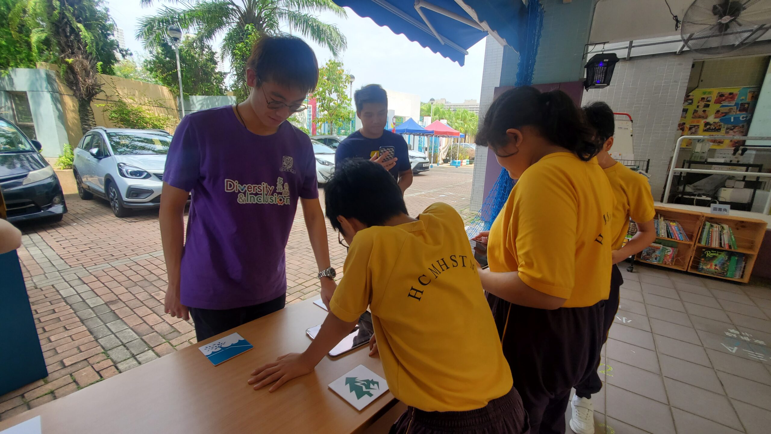 A D&I Ambassador is engaging students from Hong Chi Morninghope School in an interactive card matching workshop.