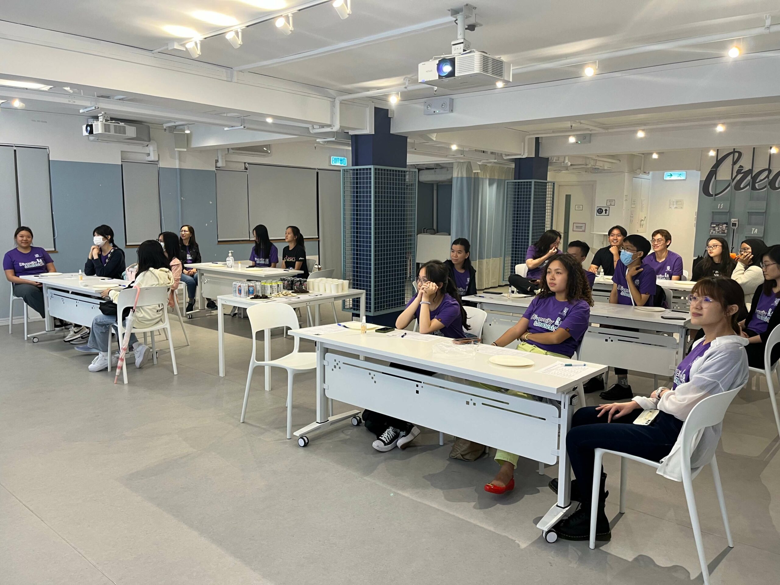 The ambassadors are seated in the classroom, attentively listening to the speaker’s presentation