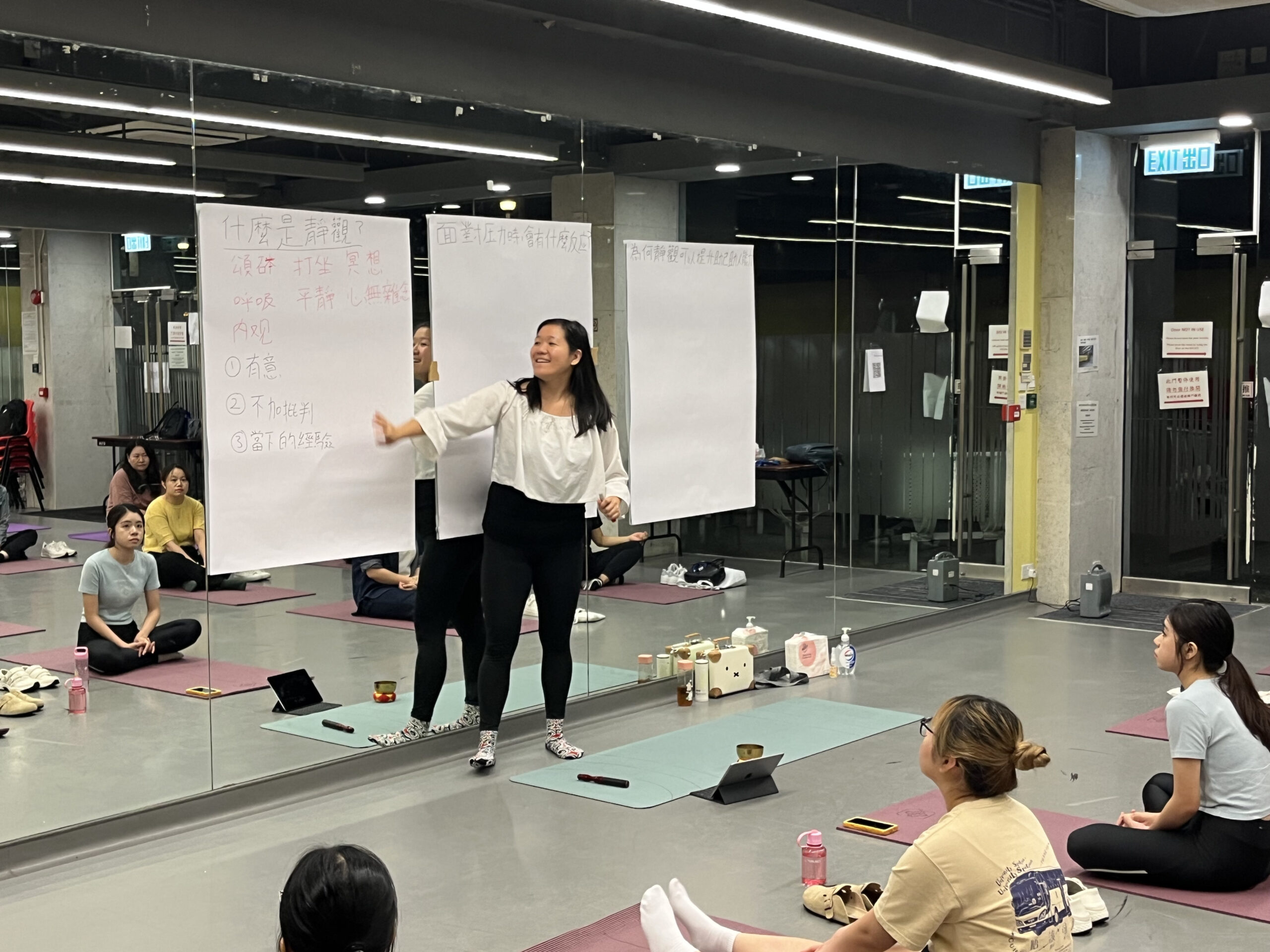 Instructor of the workshop stands before a group, confidently presenting her topic and interacting with the audience during the session.