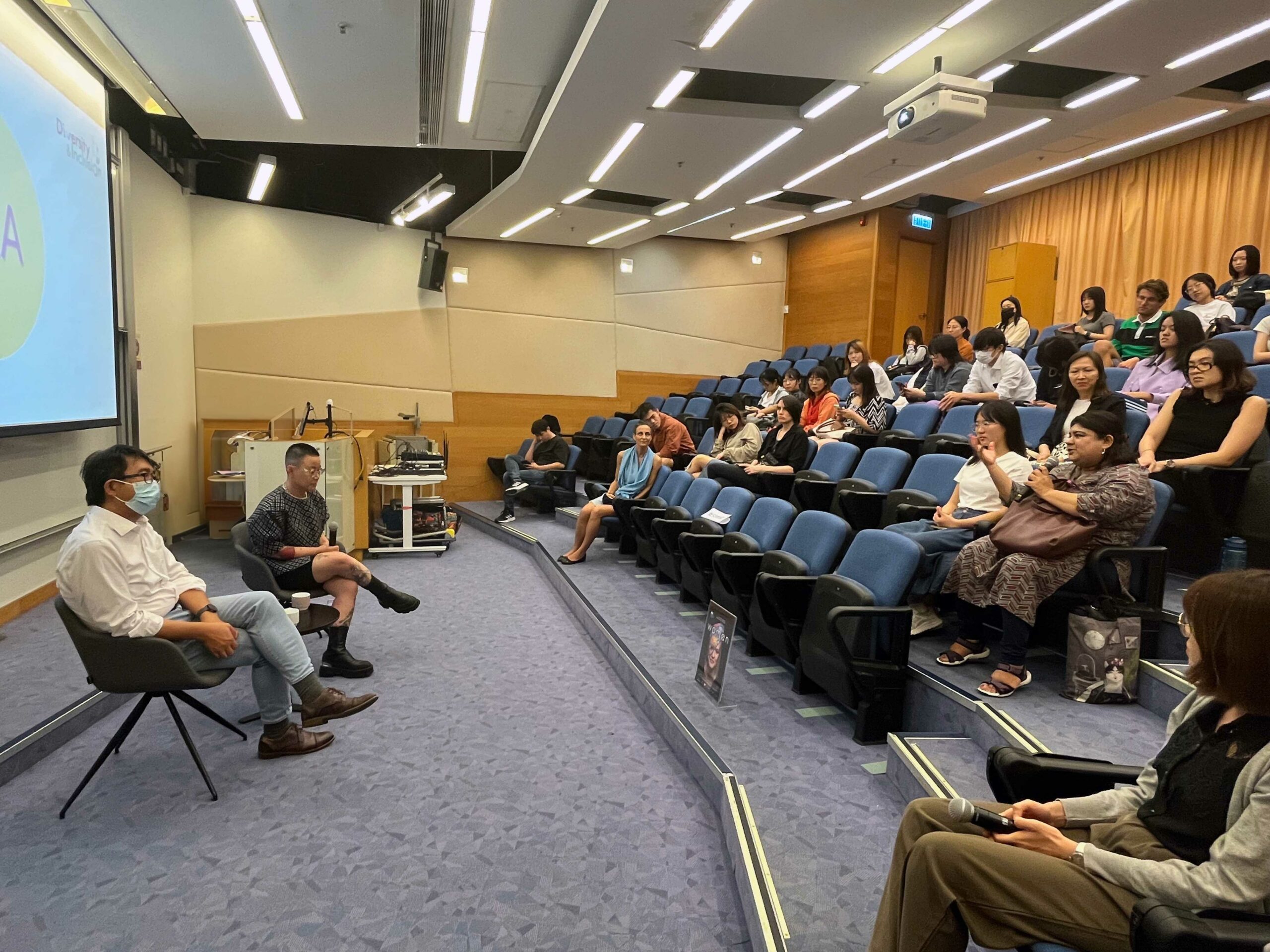 A event participant is asking questions to the two speakers.