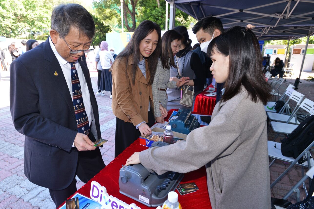 Prof. Rocky Tuan is participating in a workshop on making braille bookmarks, assisted by a representative from The Ebenezer School and Home for the Visually Impaired.