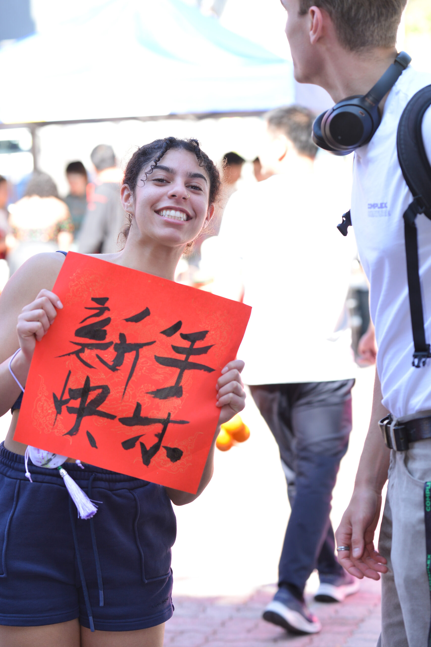 A student holding the fai chun she wrote at the workshop.