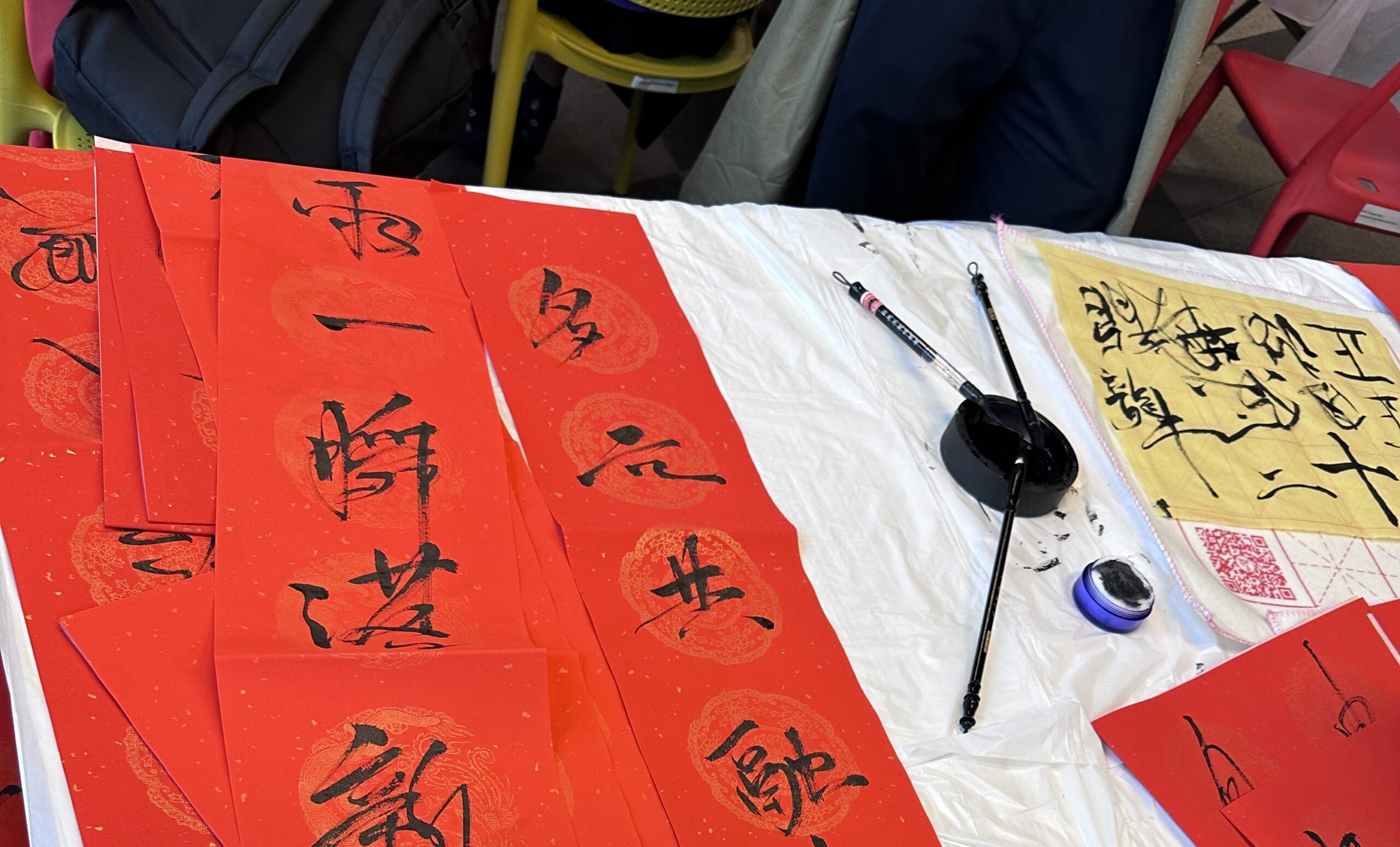 A table covered with red sheets featuring Chinese calligraphy characters in black ink.