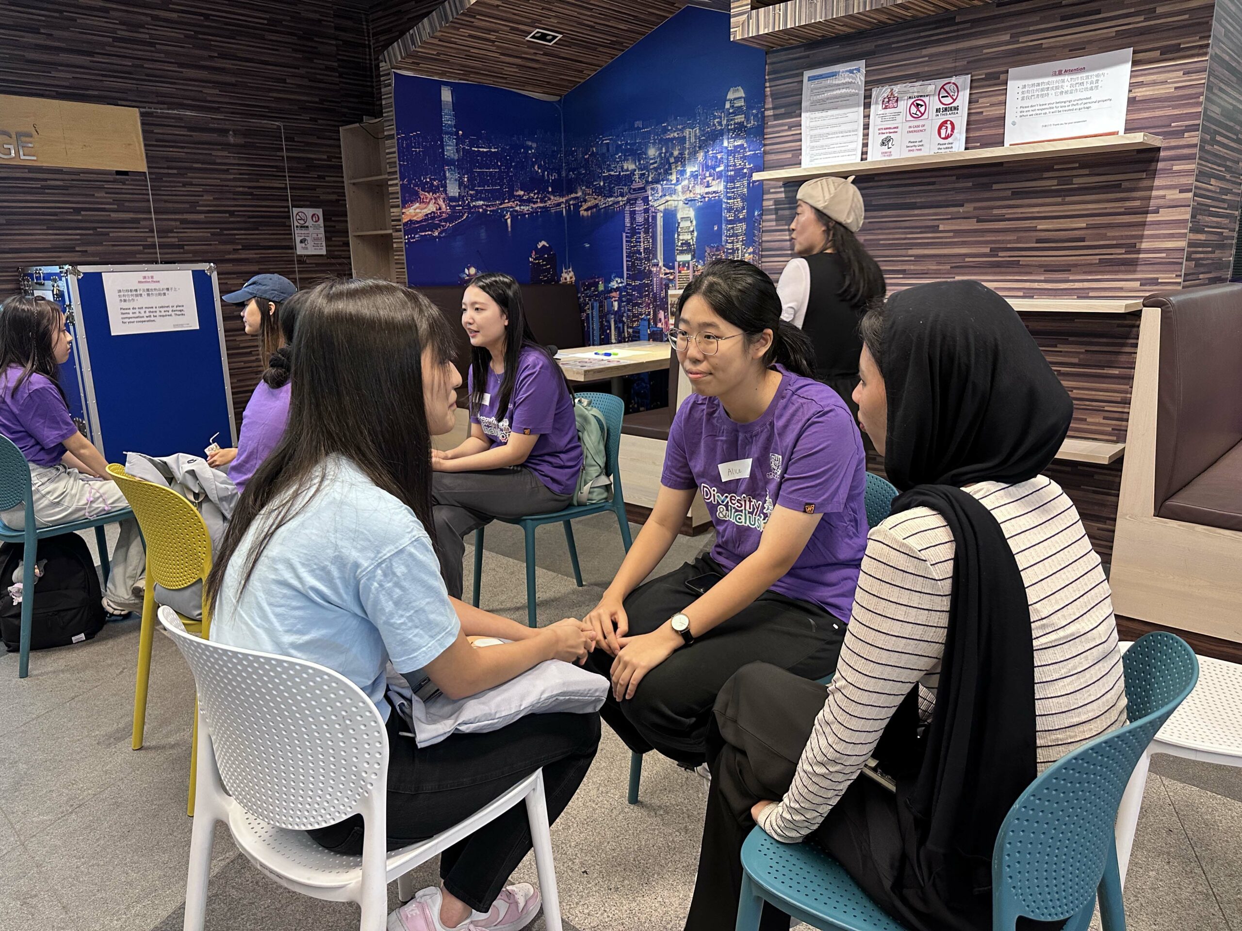 A group of D&I ambassadors sits in pairs, engaging in discussion