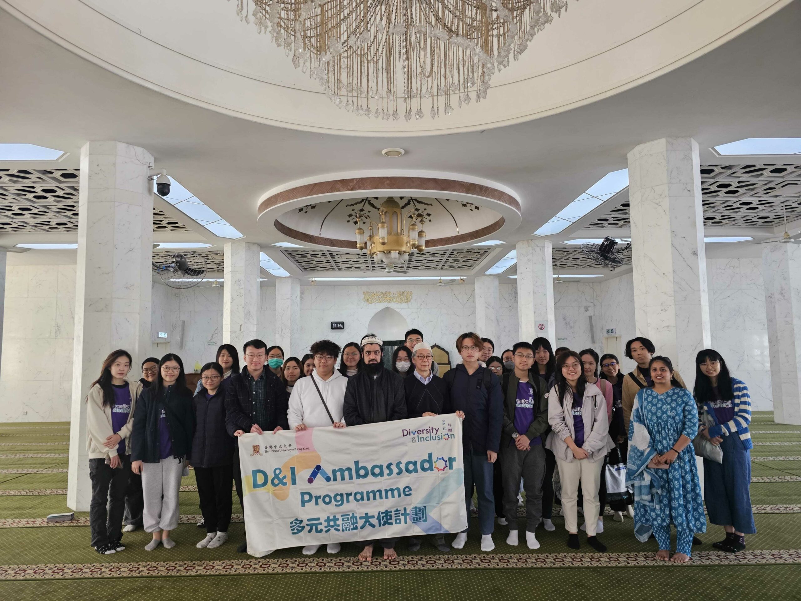 A group photo of the D&I ambassadors with the program banner taken in the mosque.