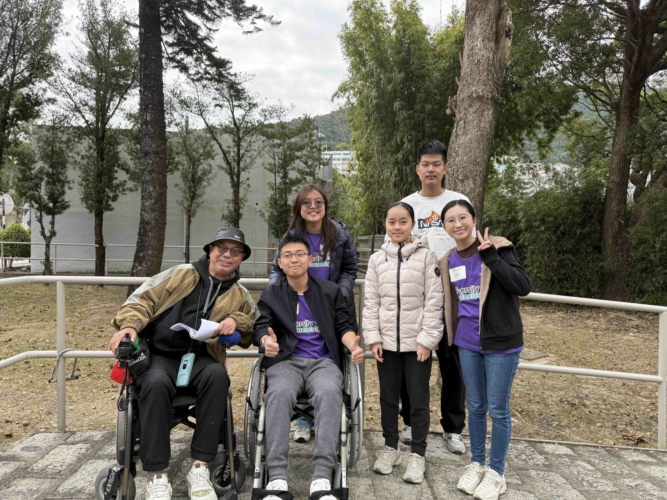 A photo of D&I ambassadors gathered around a wheelchair tutor; one of the ambassadors is also sitting in a wheelchair.